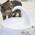Tabby cat drinking fresh running water from automatic white pet water fountain dispenser
