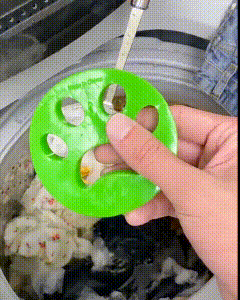 Pet Hair Remover green paw-shaped flexible silicone tool capturing animal hair from clothes inside a washing machine.